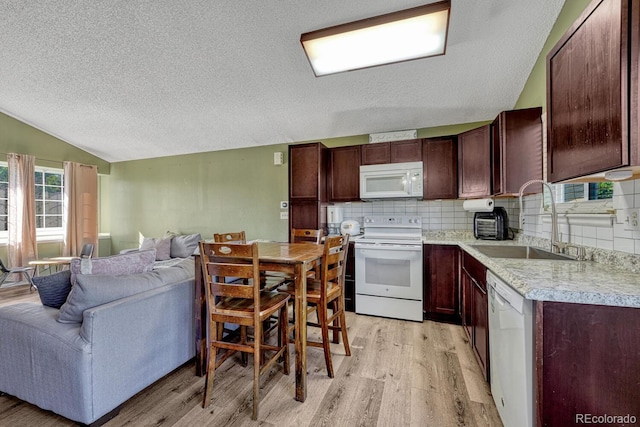 3730 Hazelwood Ct, Colorado Springs, CO 80918 - kitchen featuring white appliances, a textured ceiling, light wood-style floors, vaulted ceiling, and open floor plan