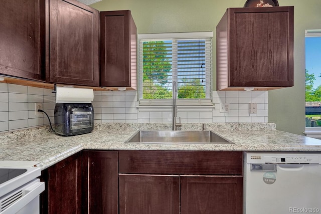 3730 Hazelwood Ct, Colorado Springs, CO 80918 - kitchen with white dishwasher, dark brown cabinetry, tasteful backsplash, and stove