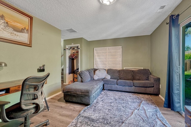 3730 Hazelwood Ct, Colorado Springs, CO 80918 - living area with light wood-style floors, a textured ceiling, and stairs