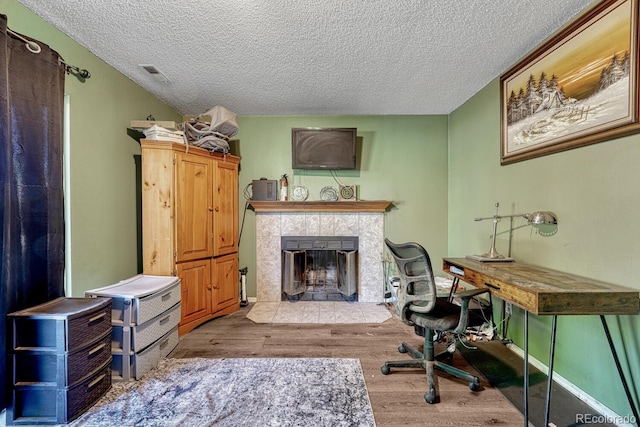 3730 Hazelwood Ct, Colorado Springs, CO 80918 - office area with a textured ceiling, wood finished floors, and a fireplace