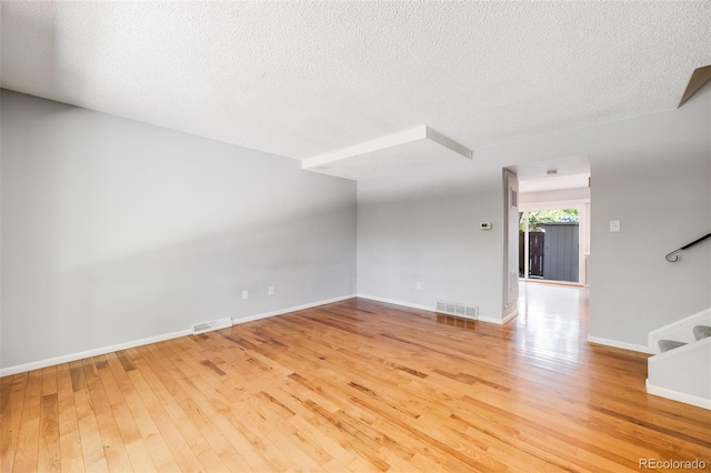 unfurnished living room with hardwood / wood-style floors and a textured ceiling