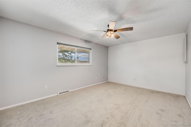 carpeted empty room with ceiling fan and a textured ceiling