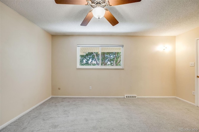 carpeted empty room featuring ceiling fan and a textured ceiling