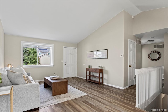 living room with vaulted ceiling and wood-type flooring