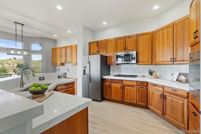 828 Rabbit Run Dr, Golden, CO 80401 - kitchen with stainless steel appliances, light wood-style flooring, recessed lighting, decorative light fixtures, and brown cabinets