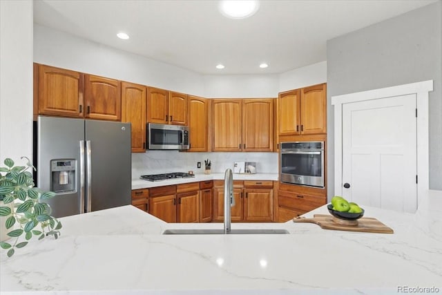 828 Rabbit Run Dr, Golden, CO 80401 - kitchen with appliances with stainless steel finishes, brown cabinetry, light stone counters, and recessed lighting