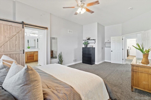 828 Rabbit Run Dr, Golden, CO 80401 - bedroom featuring light carpet, a barn door, connected bathroom, and a ceiling fan