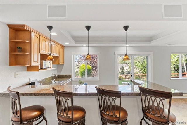 828 Rabbit Run Dr, Golden, CO 80401 - kitchen with a tray ceiling, a breakfast bar, a peninsula, open shelves, and pendant lighting