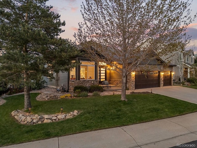 828 Rabbit Run Dr, Golden, CO 80401 - view of front of home with stone siding, concrete driveway, a lawn, and an attached garage