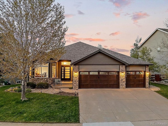 828 Rabbit Run Dr, Golden, CO 80401 - view of front of home with a garage, concrete driveway, stone siding, a lawn, and a shingled roof