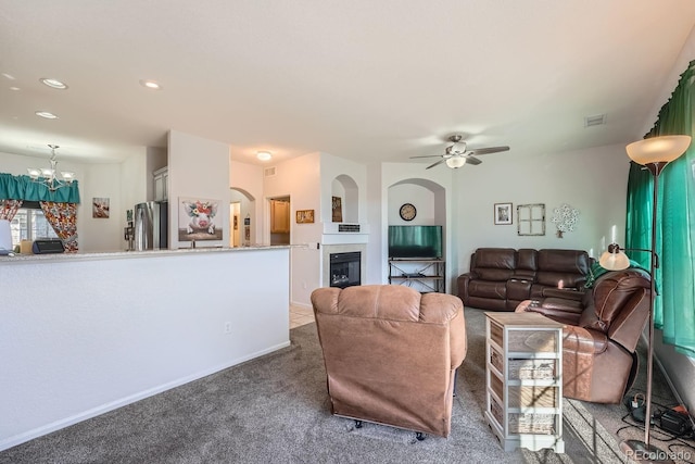 living room with ceiling fan with notable chandelier and carpet floors