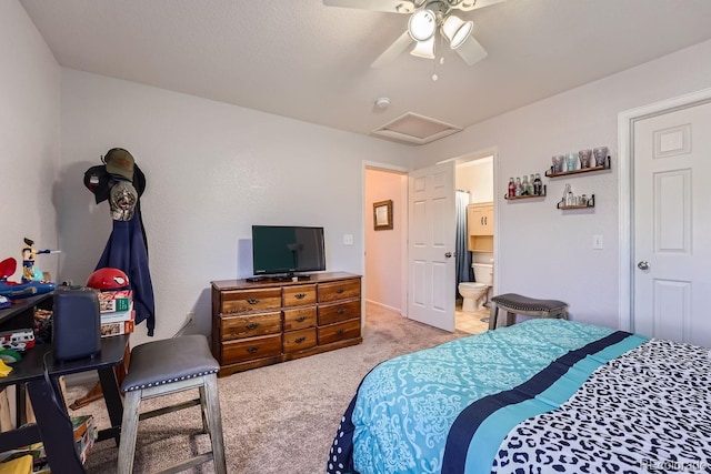 bedroom with ceiling fan, light colored carpet, and ensuite bathroom