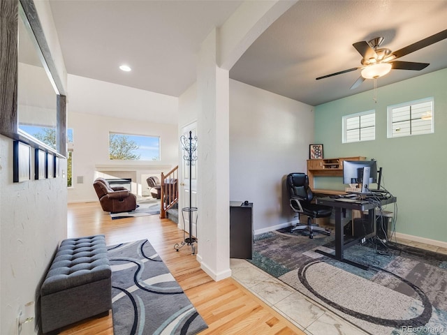 home office with arched walkways, healthy amount of natural light, wood finished floors, a ceiling fan, and recessed lighting