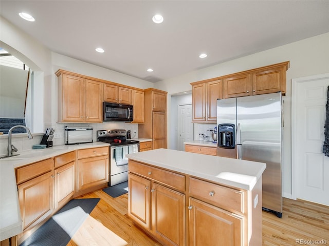 kitchen featuring appliances with stainless steel finishes, light wood finished floors, decorative backsplash, light countertops, and recessed lighting
