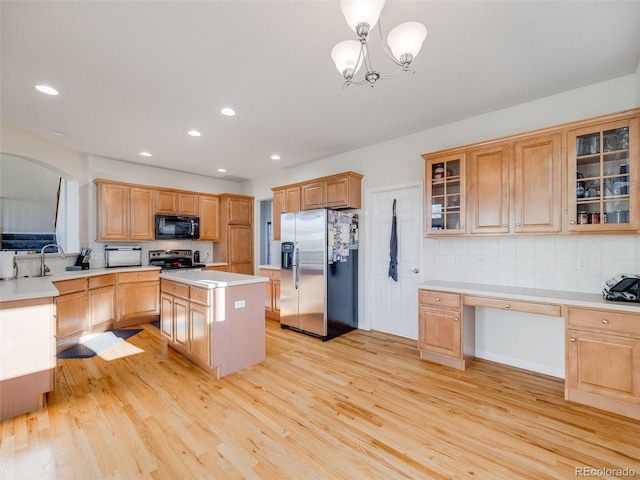 kitchen with appliances with stainless steel finishes, backsplash, light wood-type flooring, a kitchen island, and recessed lighting
