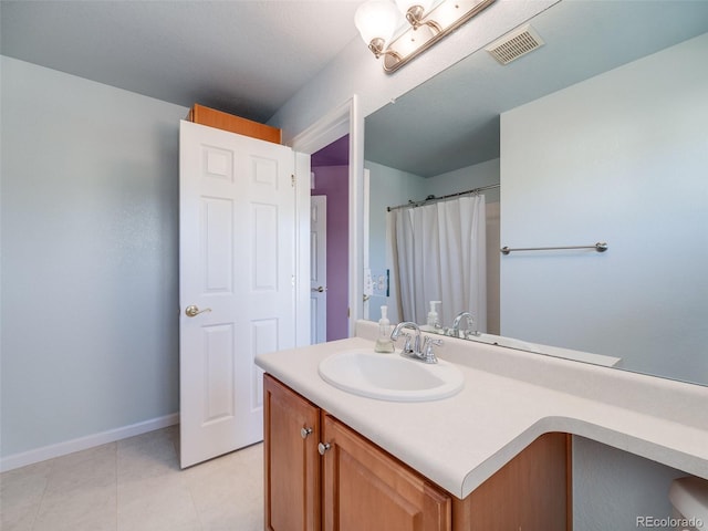 bathroom featuring vanity, baseboards, and tile patterned floors