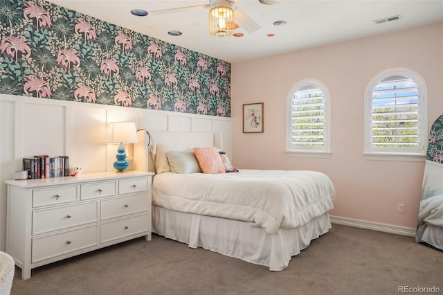 bedroom with wallpapered walls, visible vents, wainscoting, and carpet