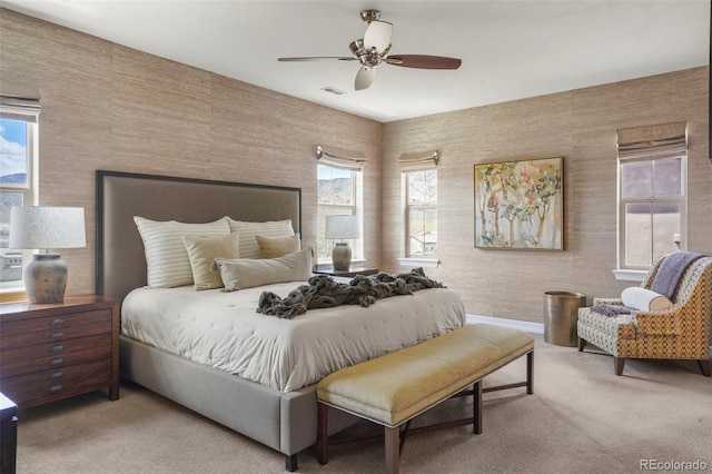 carpeted bedroom featuring baseboards, multiple windows, a ceiling fan, and visible vents