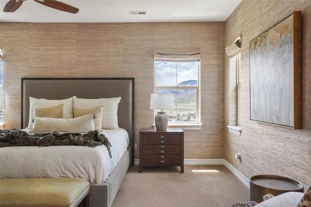 bedroom featuring light colored carpet, baseboards, visible vents, and a ceiling fan