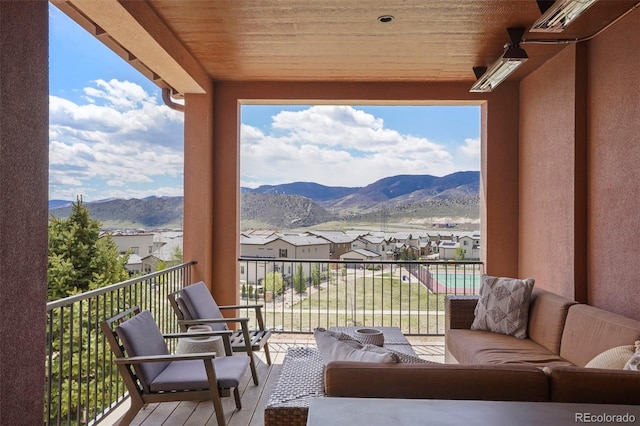 balcony with an outdoor living space, a residential view, and a mountain view