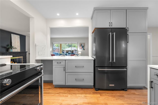 kitchen with high end fridge, electric range, gray cabinetry, and recessed lighting