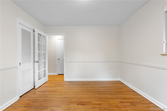 unfurnished bedroom featuring light wood-type flooring, baseboards, and french doors