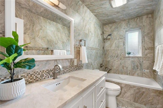 full bathroom featuring tiled shower / bath, toilet, tasteful backsplash, vanity, and tile walls
