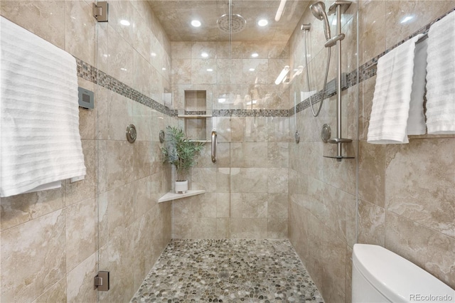full bathroom with a stall shower and toilet