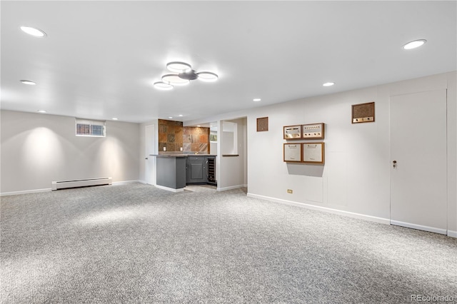 unfurnished living room with a baseboard radiator, wet bar, recessed lighting, light colored carpet, and baseboards