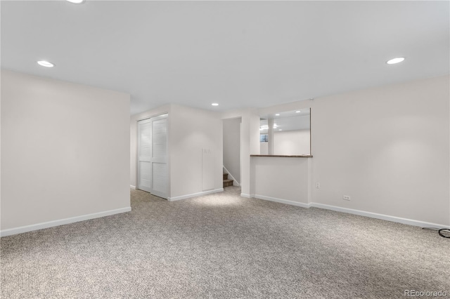 carpeted empty room featuring recessed lighting, baseboards, and stairway