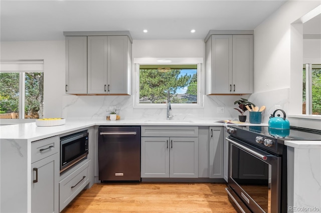 kitchen featuring appliances with stainless steel finishes, gray cabinetry, healthy amount of natural light, and recessed lighting