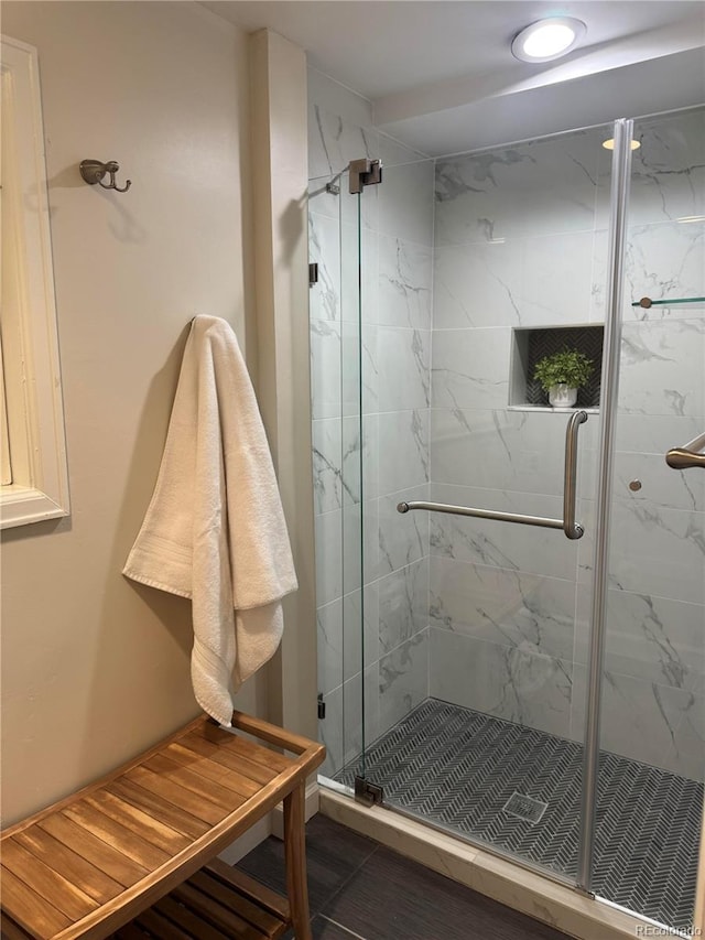 bathroom featuring a marble finish shower