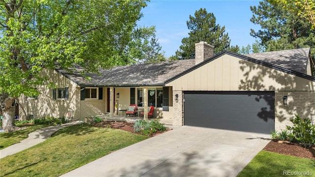 ranch-style home featuring covered porch, brick siding, an attached garage, and a front yard