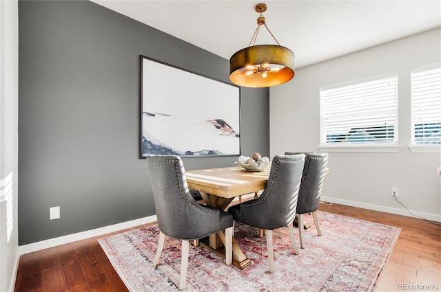 dining area featuring hardwood / wood-style floors and a notable chandelier