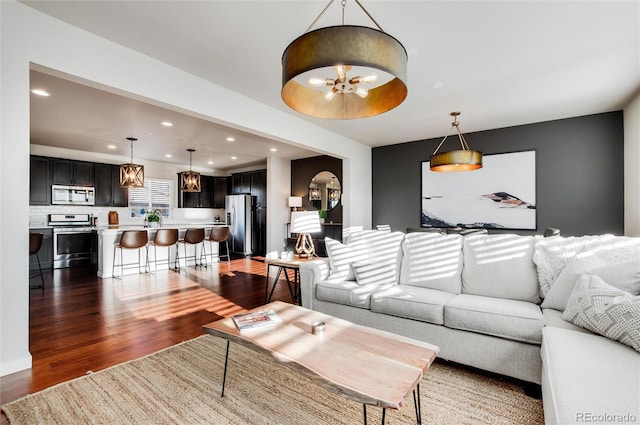 living room with an inviting chandelier, dark hardwood / wood-style floors, and sink