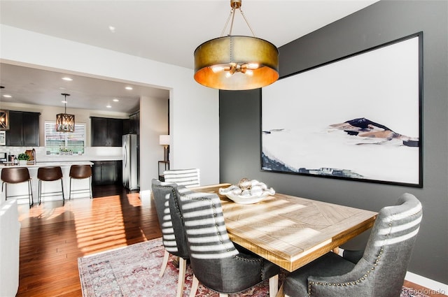 dining space featuring hardwood / wood-style flooring and a notable chandelier