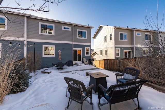 snow covered house featuring a fire pit