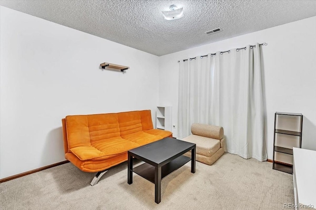 sitting room with light carpet and a textured ceiling