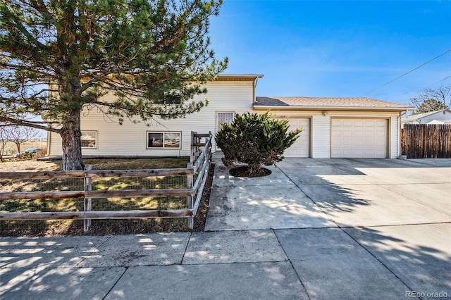 view of front facade with a fenced front yard, driveway, and an attached garage