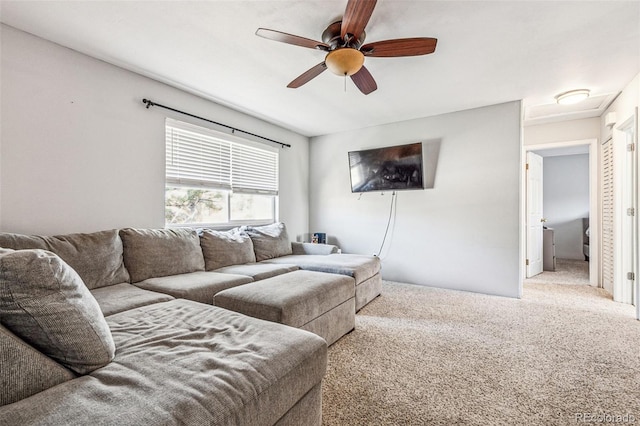 carpeted living area with ceiling fan