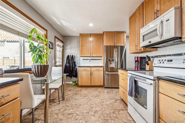 kitchen with white appliances, dark countertops, and tasteful backsplash