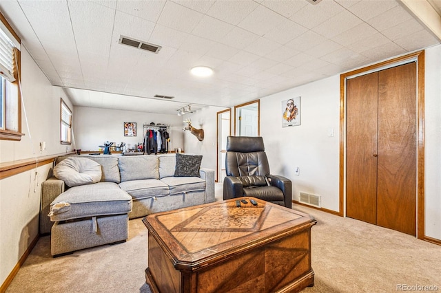 carpeted living room featuring visible vents and baseboards