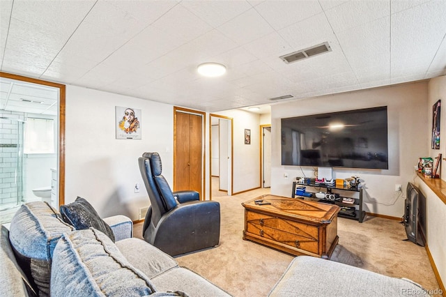 carpeted living area featuring visible vents and baseboards