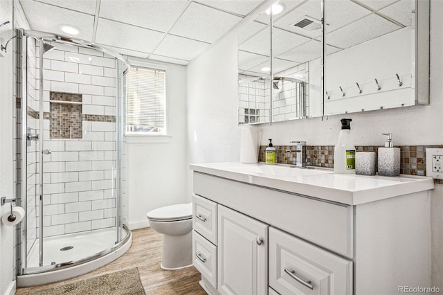 bathroom featuring visible vents, toilet, a stall shower, wood finished floors, and vanity