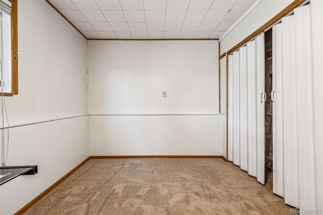 carpeted spare room with baseboards and ornamental molding