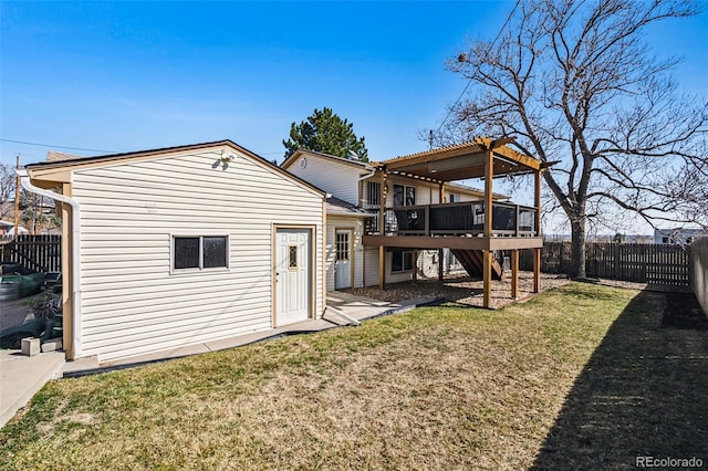 rear view of house featuring a wooden deck, a lawn, a fenced backyard, and stairs