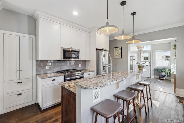 1626 Albion St, Denver, CO 80220 - kitchen featuring stainless steel appliances, tasteful backsplash, white cabinetry, a kitchen bar, and ornamental molding