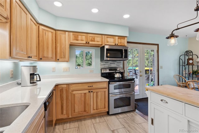 kitchen featuring recessed lighting, stainless steel appliances, hanging light fixtures, wooden counters, and decorative backsplash