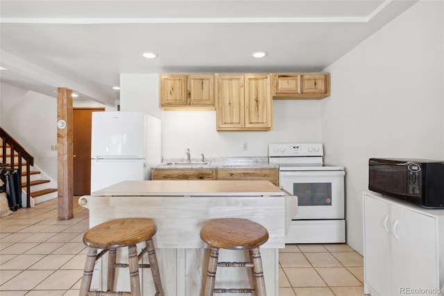 kitchen featuring light tile patterned flooring, light brown cabinets, white appliances, light countertops, and a kitchen bar