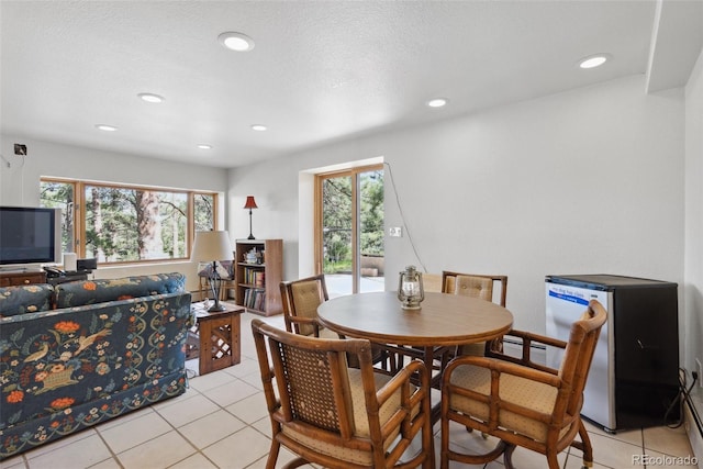 dining space with recessed lighting, a textured ceiling, and light tile patterned floors